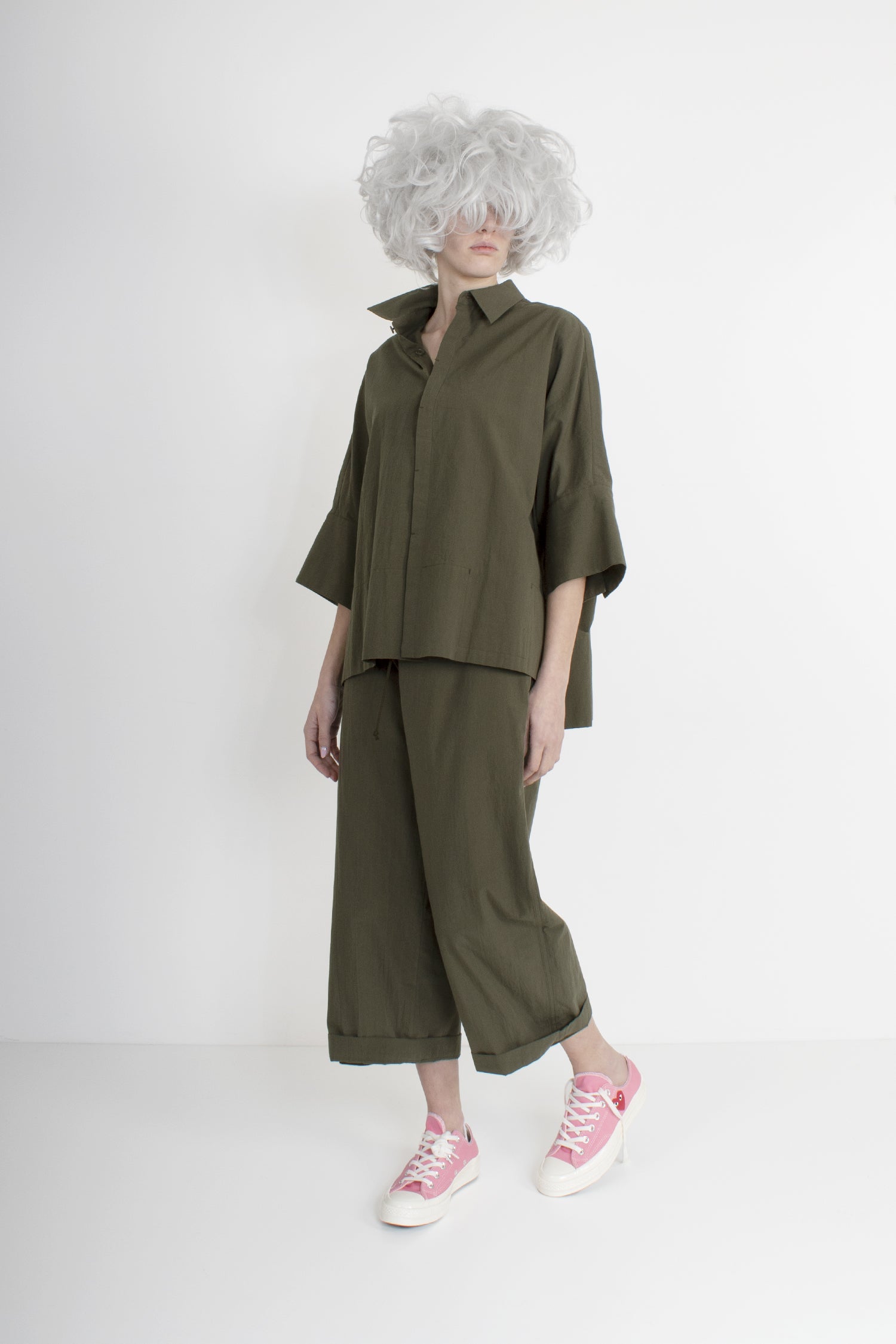 green outfit composed of green shirt, large, crumpled cotton, hidden buttons fastening, cap sleeves, big cuffs with two buttons, side slits, slightly longer on the back green trousers, crumpled cotton, large and straight leg, two hidden pockets on the sides, one patched pocket on the back, zip and buttons fastening, drawstring, lined
